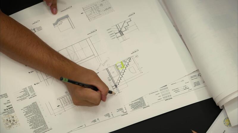 Engineering team collaborating over technical drawings